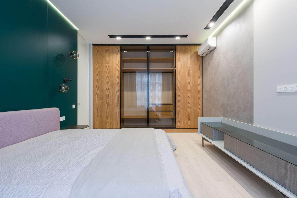 Illustrative bedroom with fitted wood and glass wardrobes